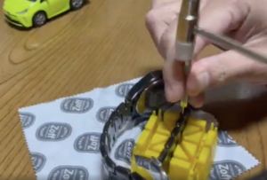 アルマーニ 時計ベルトのピンをハンマーで外しているところ