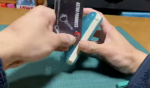 ケースの隙間にカードを差し込んで外装を開ける様子